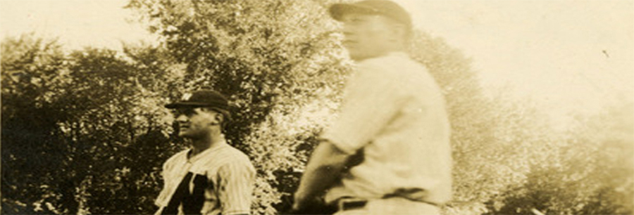 Two baseball players standing by a tree